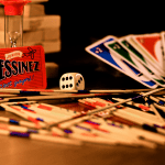 A vibrant arrangement of games, including cards, dice, and sticks, on a table.